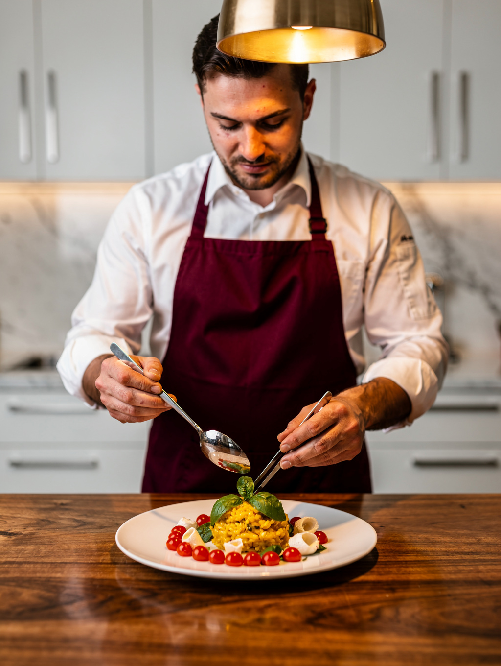 Chef delicately garnishing a seasonal Italian plate in a professional kitchen